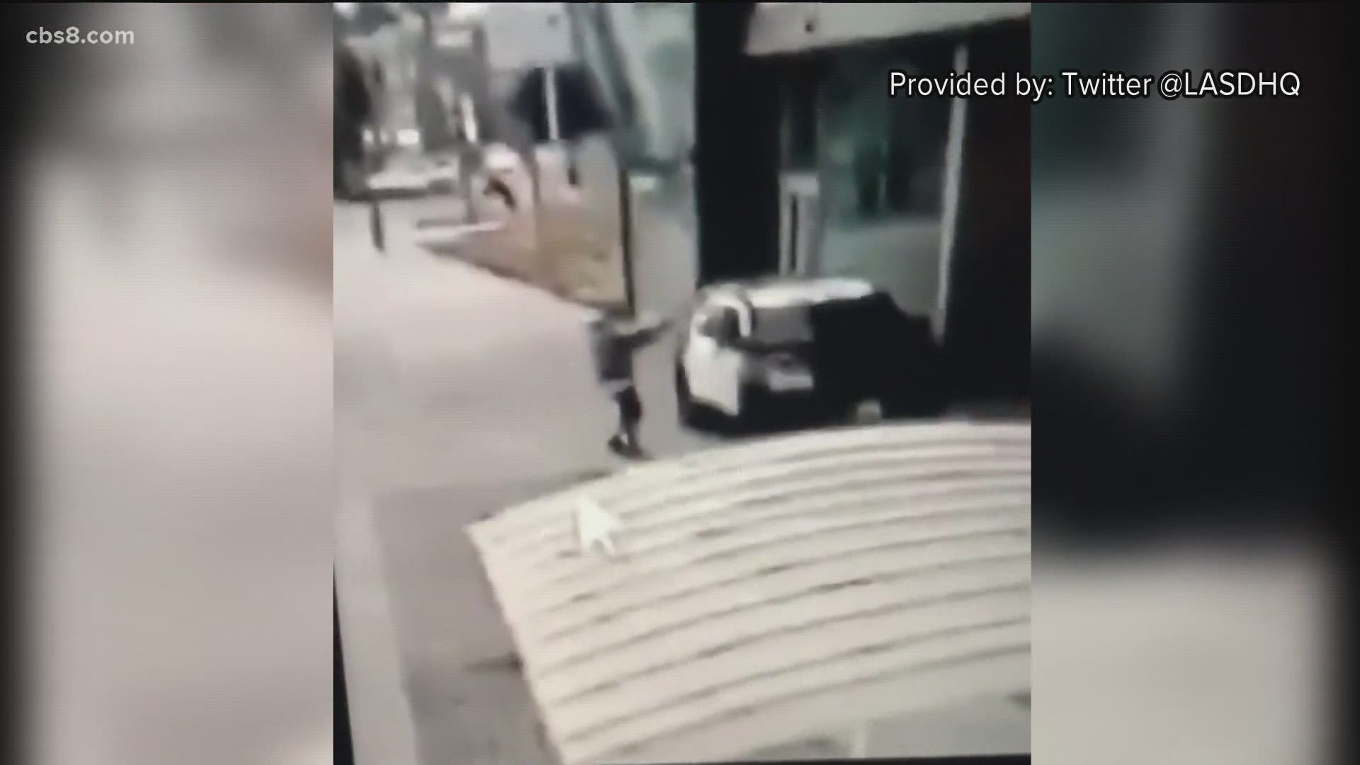 Video outside a Compton train station shows a man walking up to the deputies' parked squad car, firing several shots into the passenger window then fleeing.