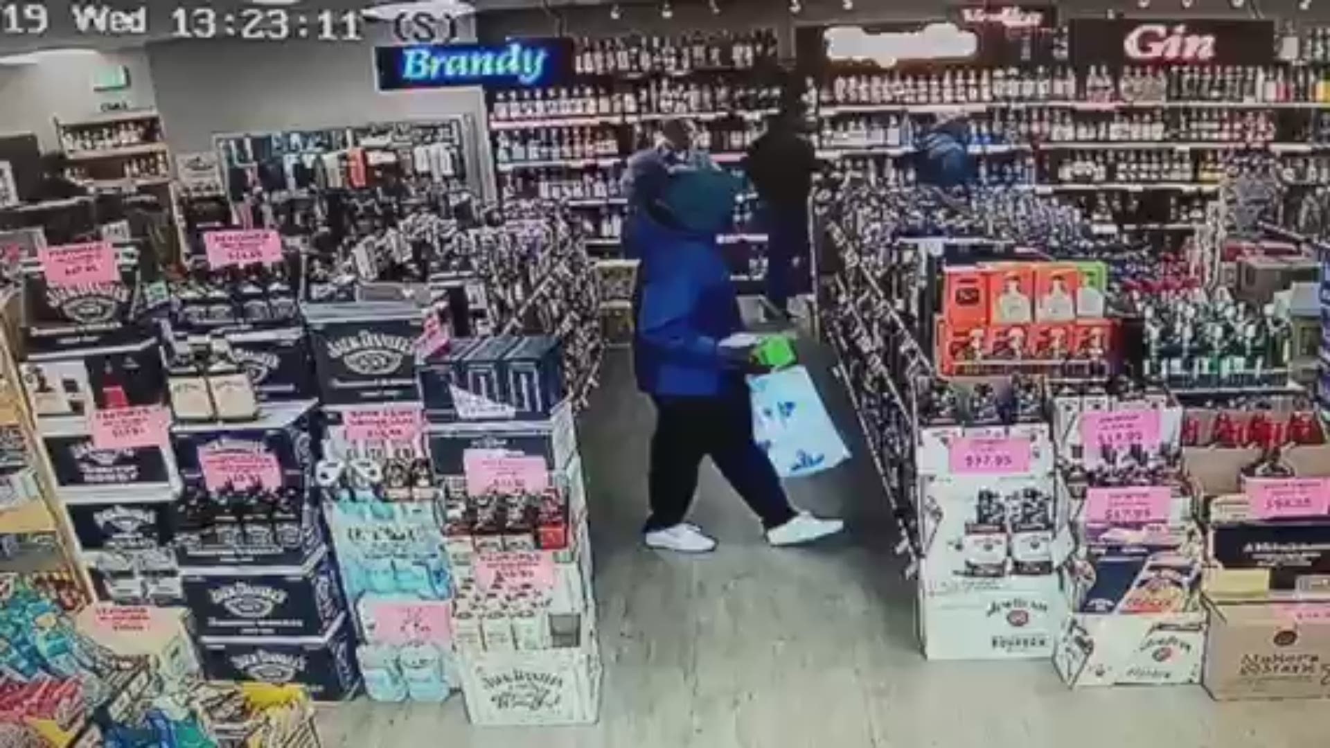 Two shoplifters were caught on camera stealing high priced bottles.
