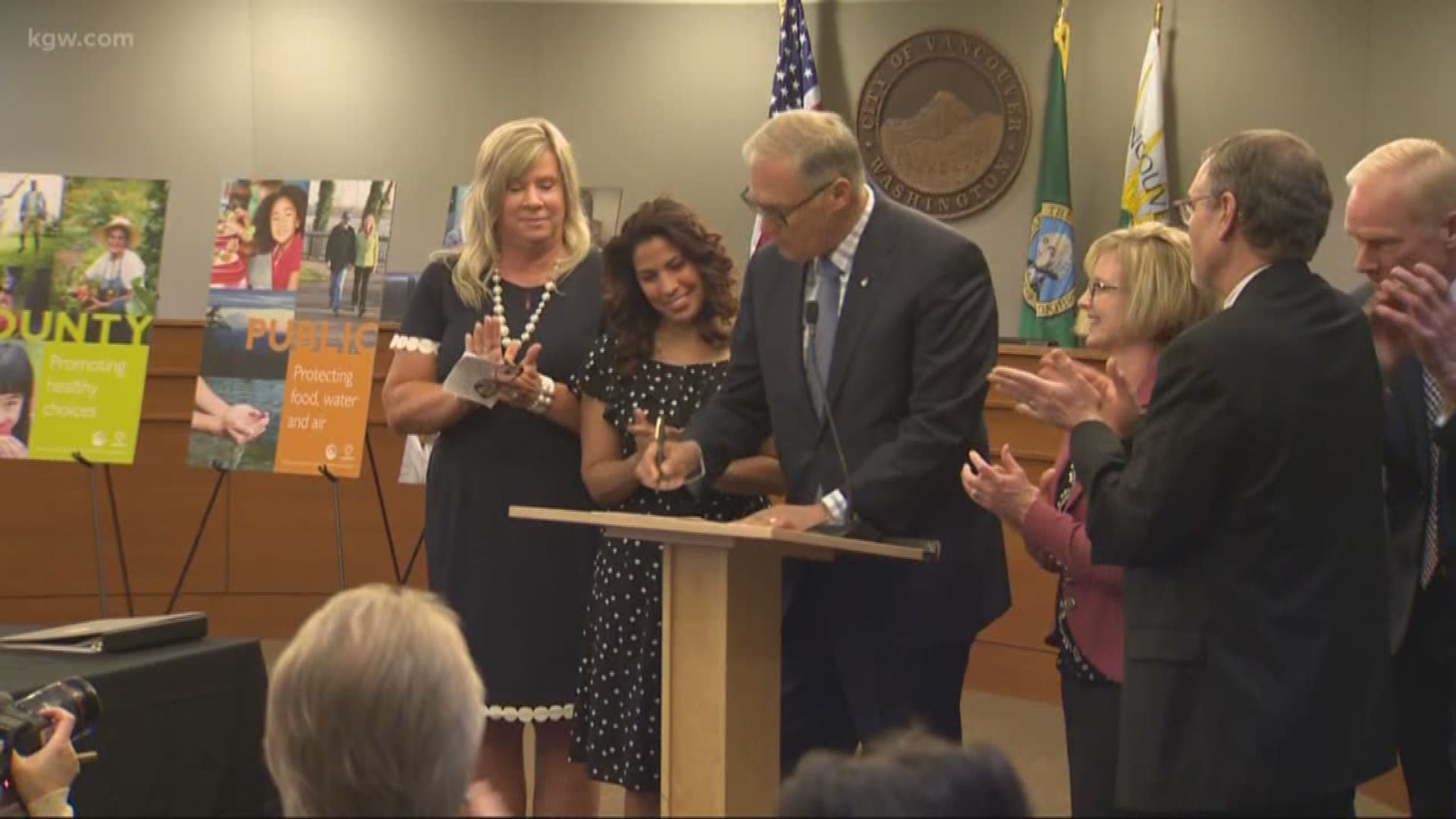 Clark County had over 70 measles cases during a recent outbreak. Gov. Jay Inslee symbolically signed a bill in Vancouver limiting vaccine exemptions, surrounded by county health officials and lawmakers who favored the bill.