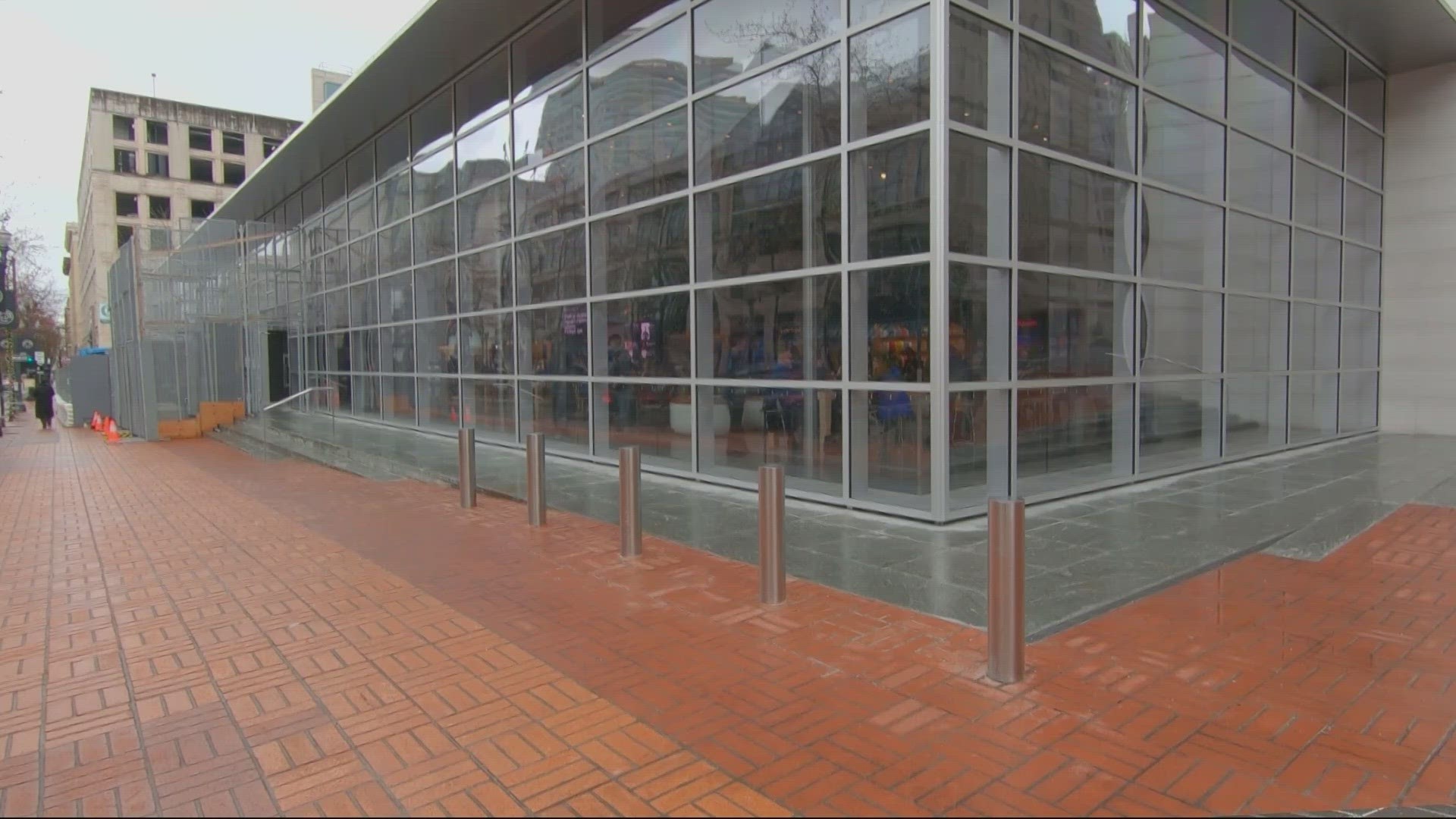 The protective barrier around the all-glass storefront has been in place for several years. Business leaders see the removal as an encouraging sign.