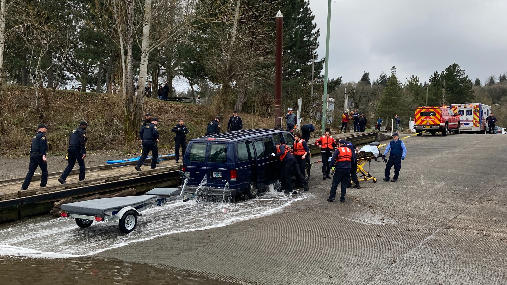 The woman was hospitalized in critical condition after being trapped in the van for about 20 minutes before fire crews were able to haul it out of the river.